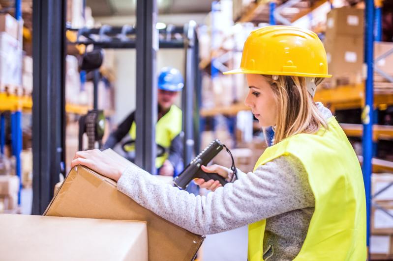 Warehouse woman worker with barcode scanner.